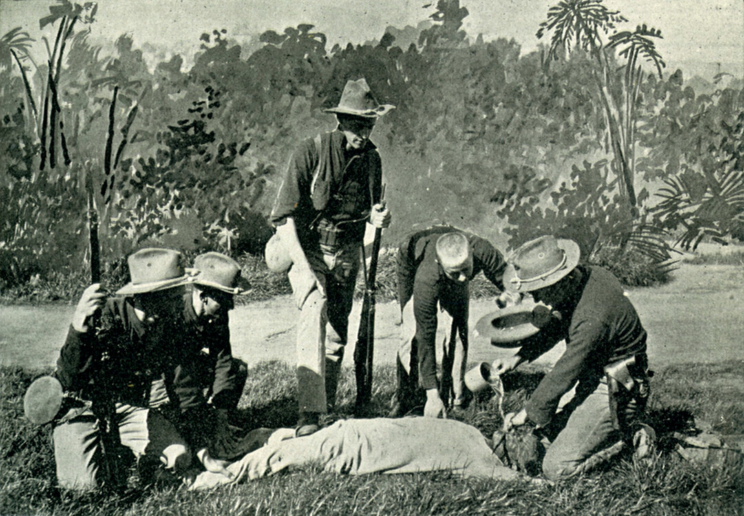People pouring water on the face of a Filipino man being held down on the ground. A sword is placed across his mouth so if he moves he will be cut.
