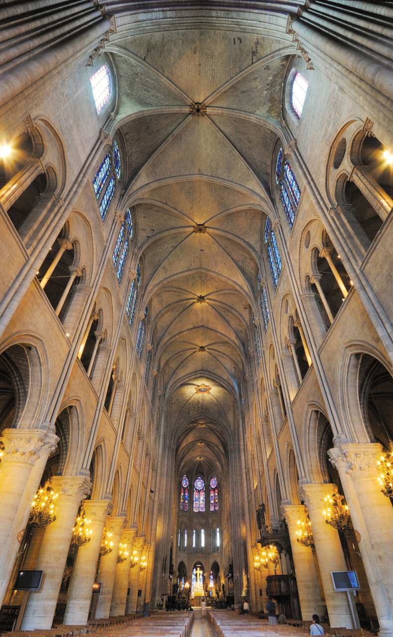 An interior view of the long, central nave and high ceiling of the Notre Dame Cathedral of Paris.