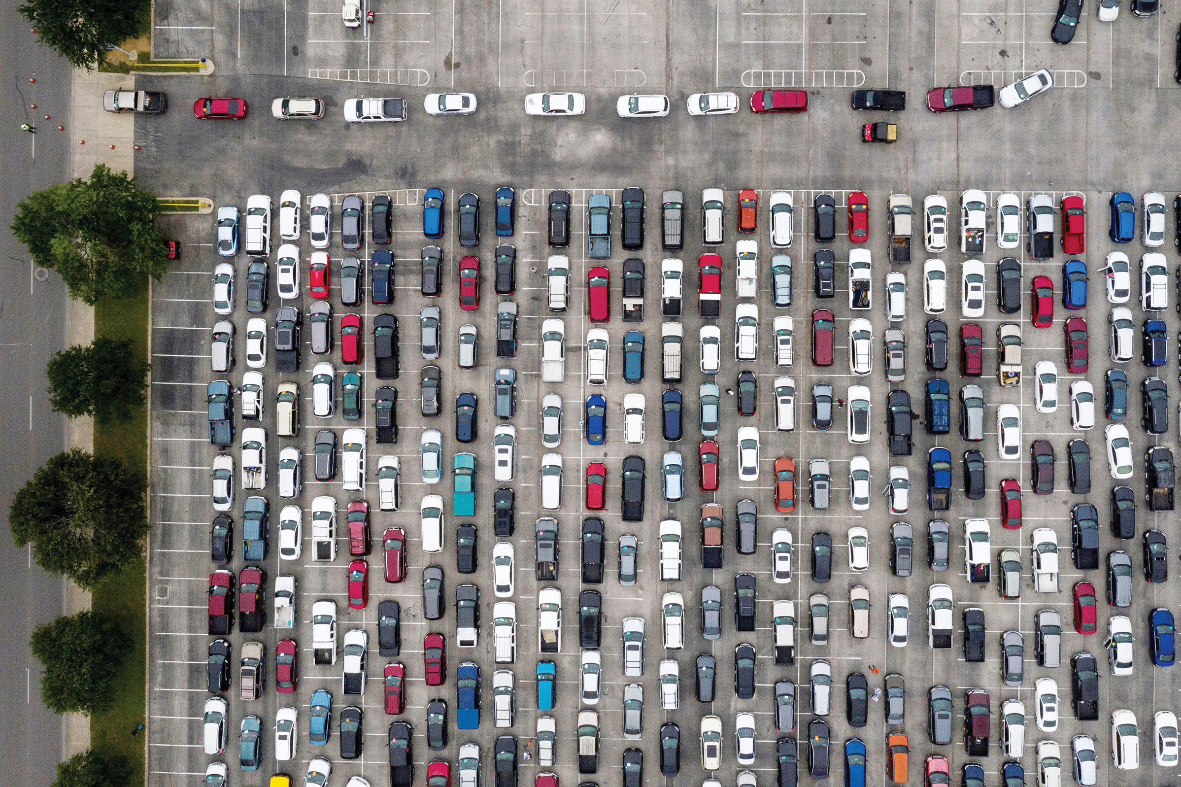 An aerial view of cars lined up in a parking lot.