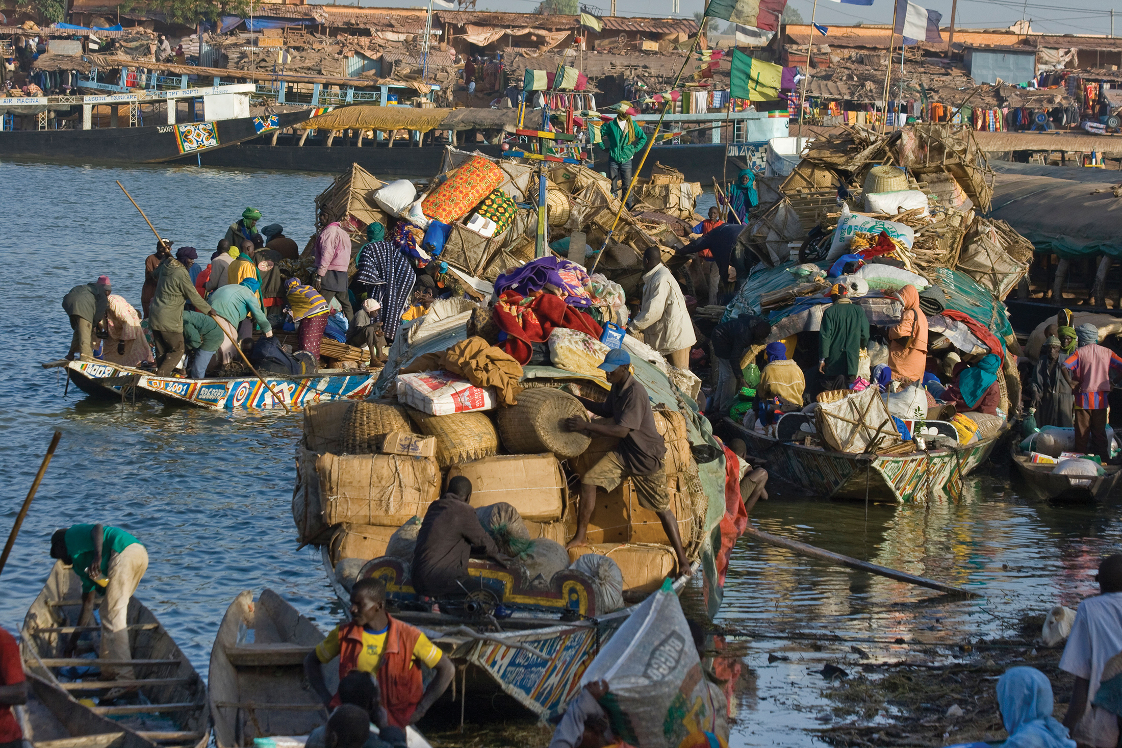 Traders steer boats filled with packages of trade goods at the port of Mopti, Mali.