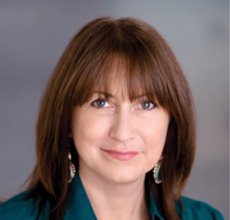 A portrait of Shannon Speed, a white woman with brown hair, wearing earrings.