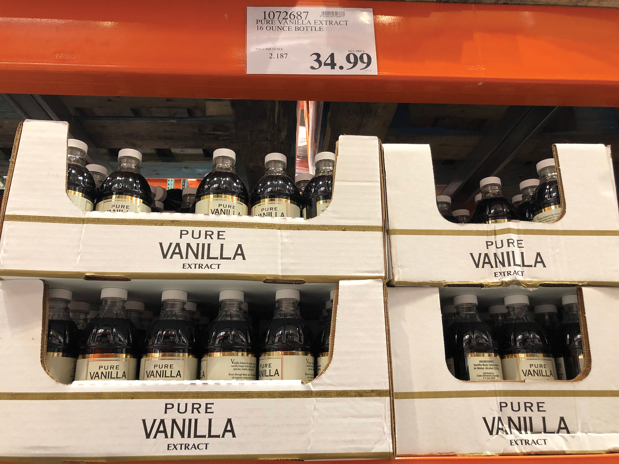 Bottles of pure vanillla extract in cardboard boxes in a store.