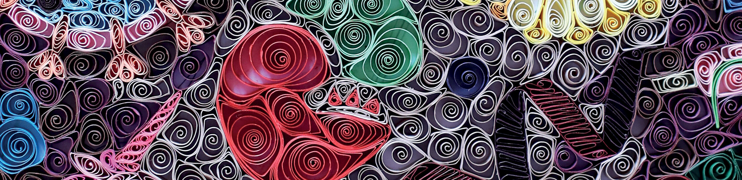 Coils of colorful paper pressed close together to form a design.