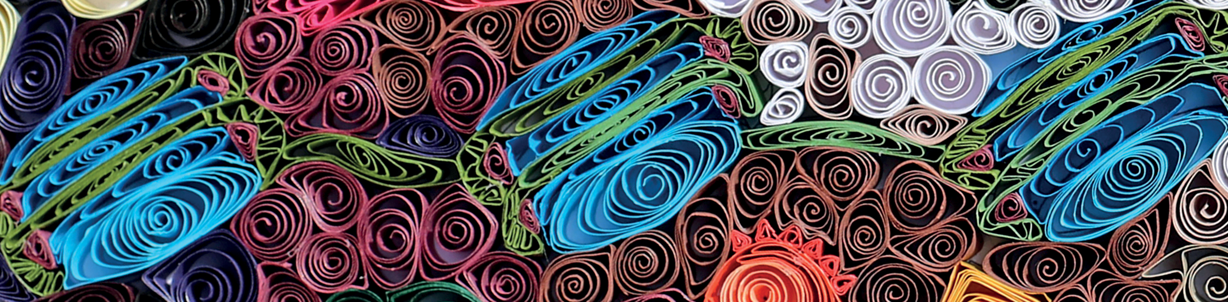 Coils of colorful paper pressed close together to form a design.