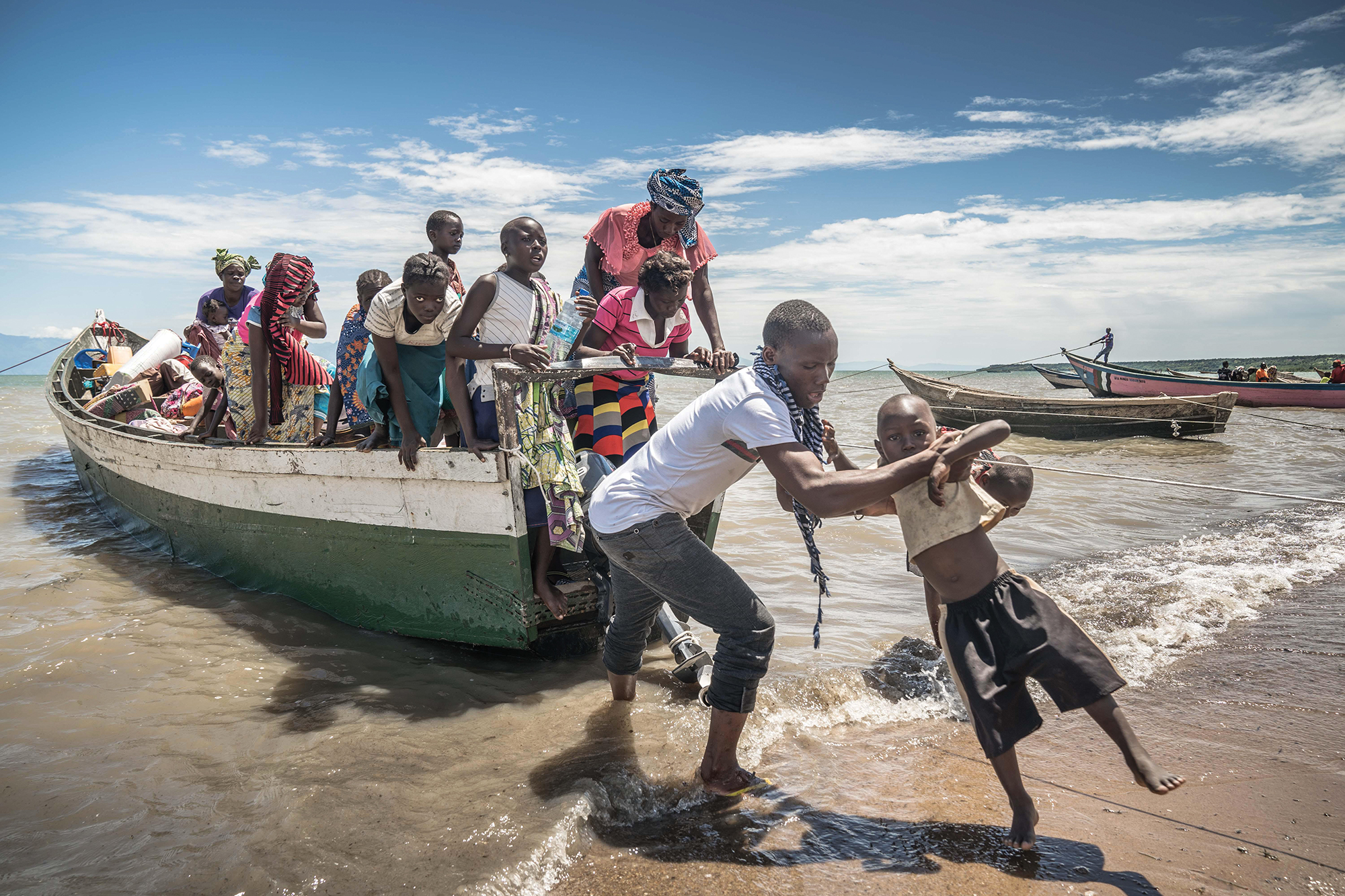 A small boat filled with Congalese refugees are waiting to get off the boat.