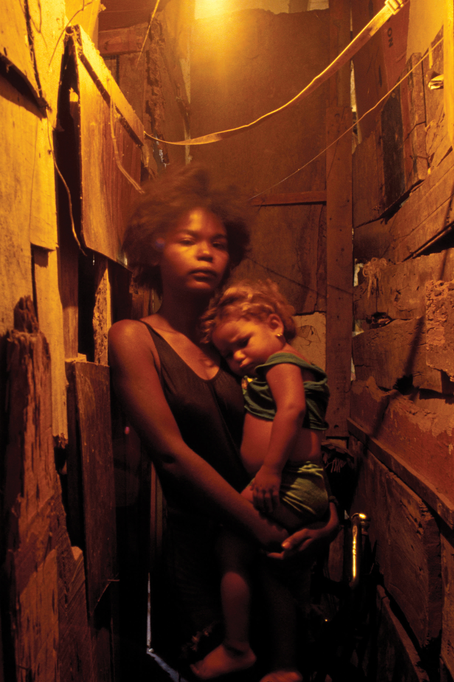 A young mother holding her toddler in her arms.