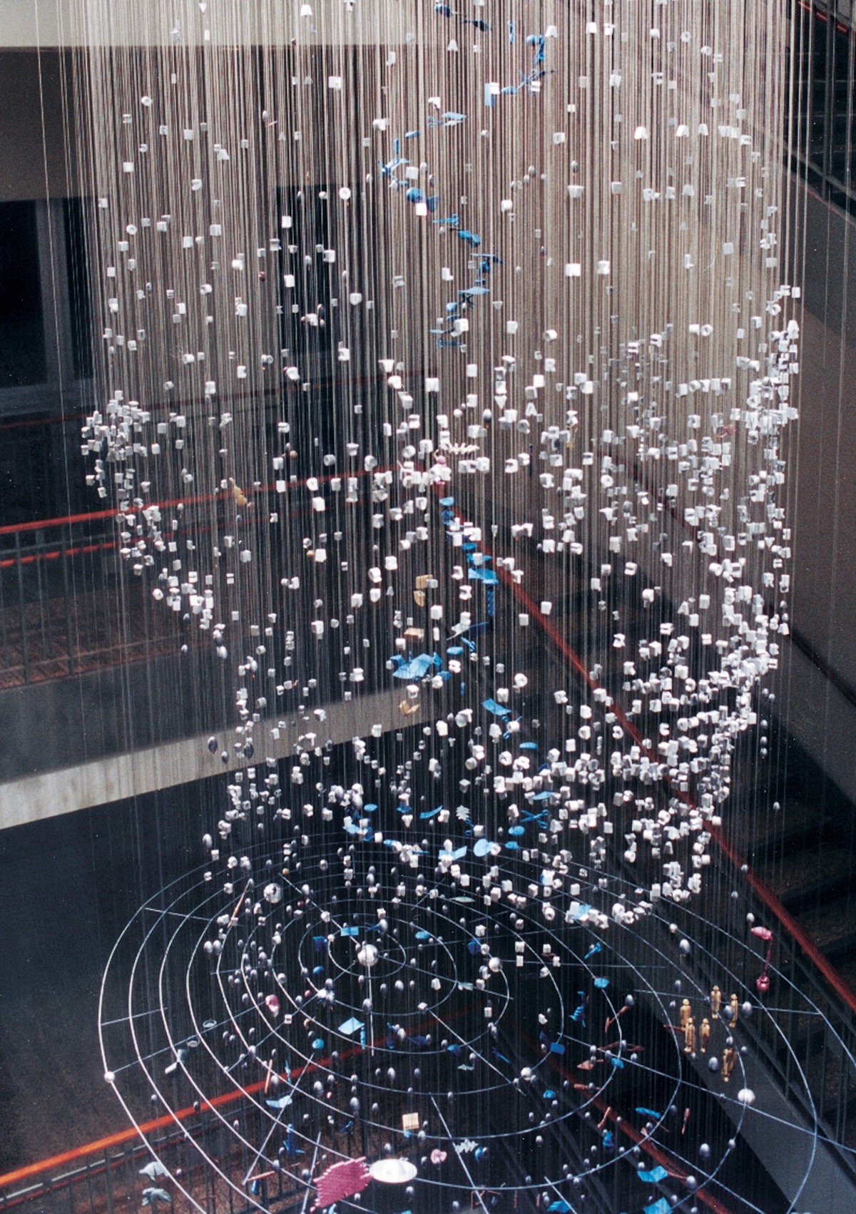 A large implied form of a human head, made from suspended pieces of metal, hung from an interior ceiling.