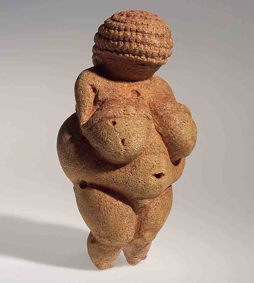 Female figure made of reddish-tan stone.