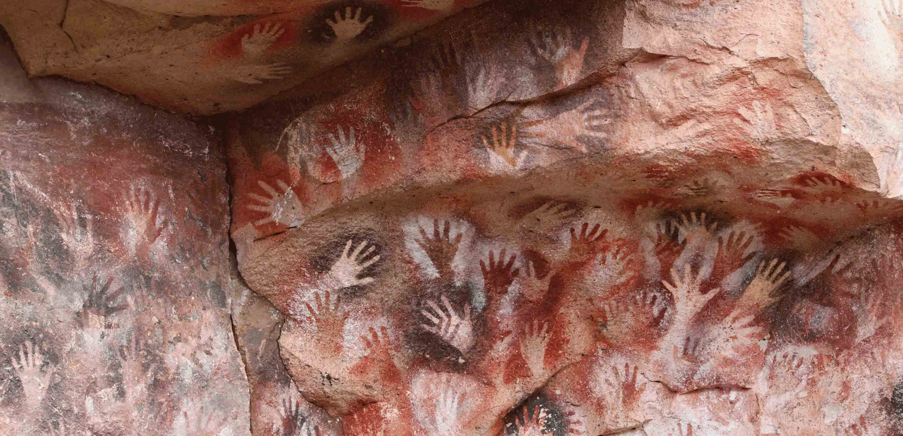 Hand images on rock face.