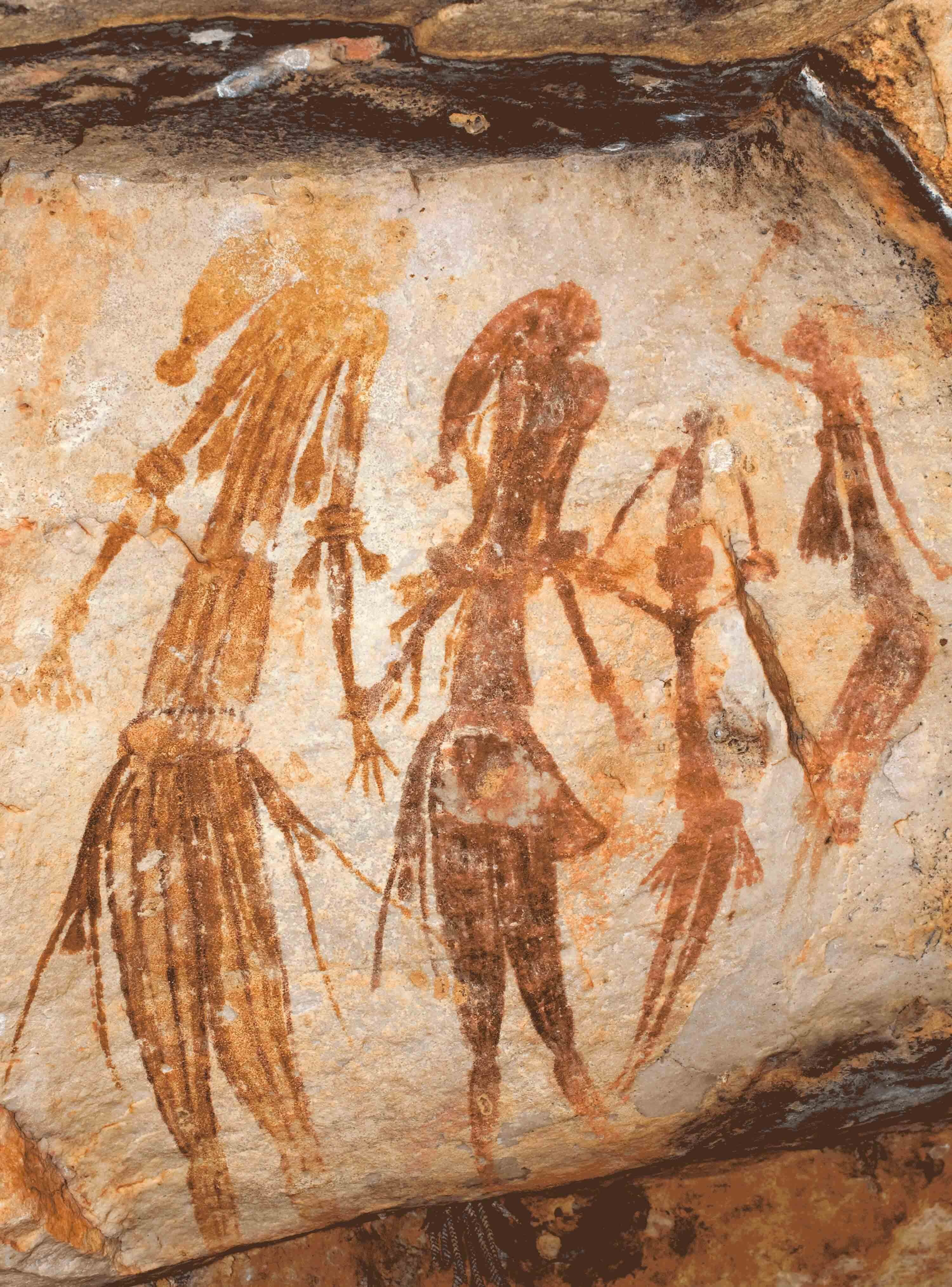 Four human figures painted on a rock surface.