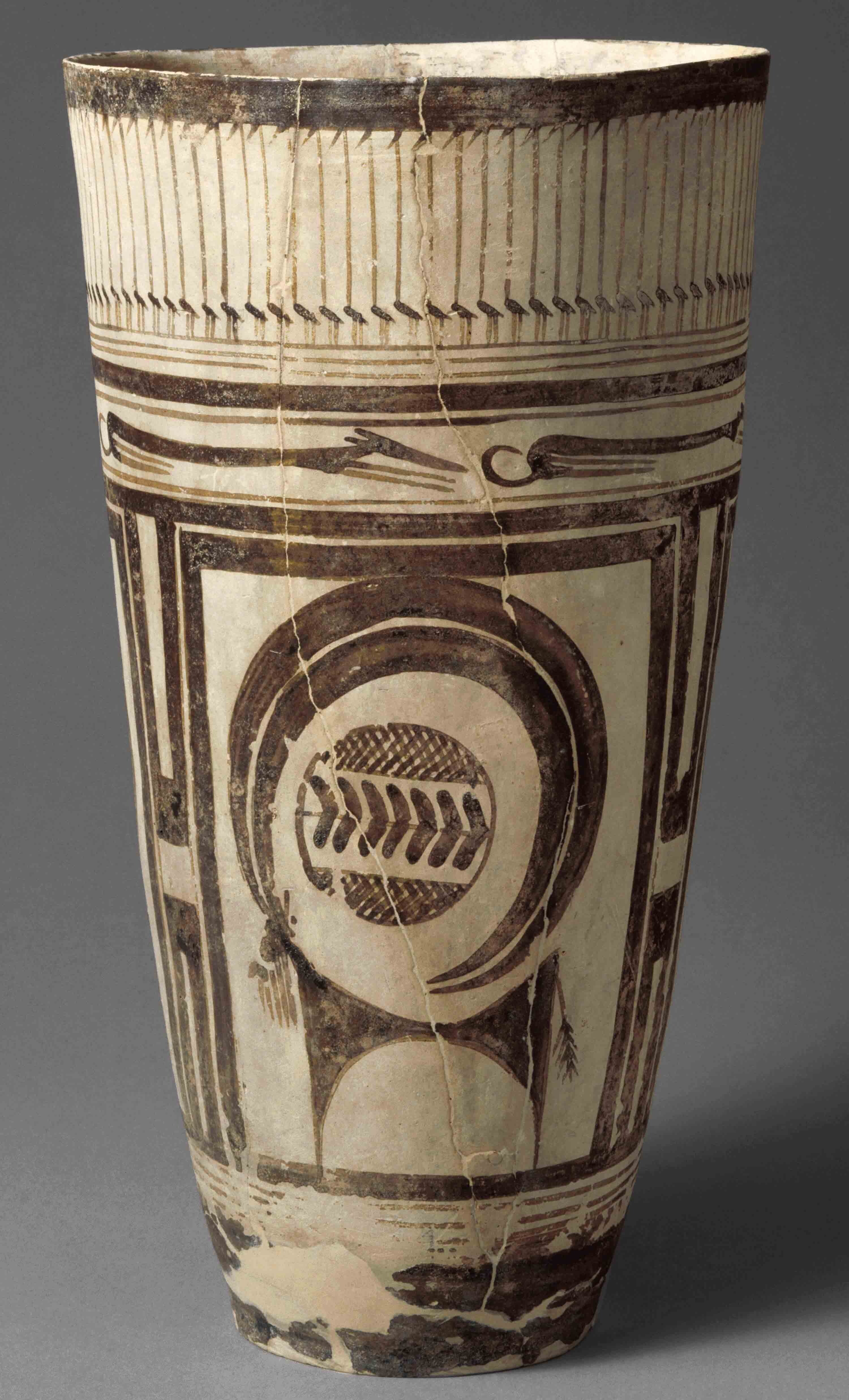 Tall white cup with painted brown decorations.