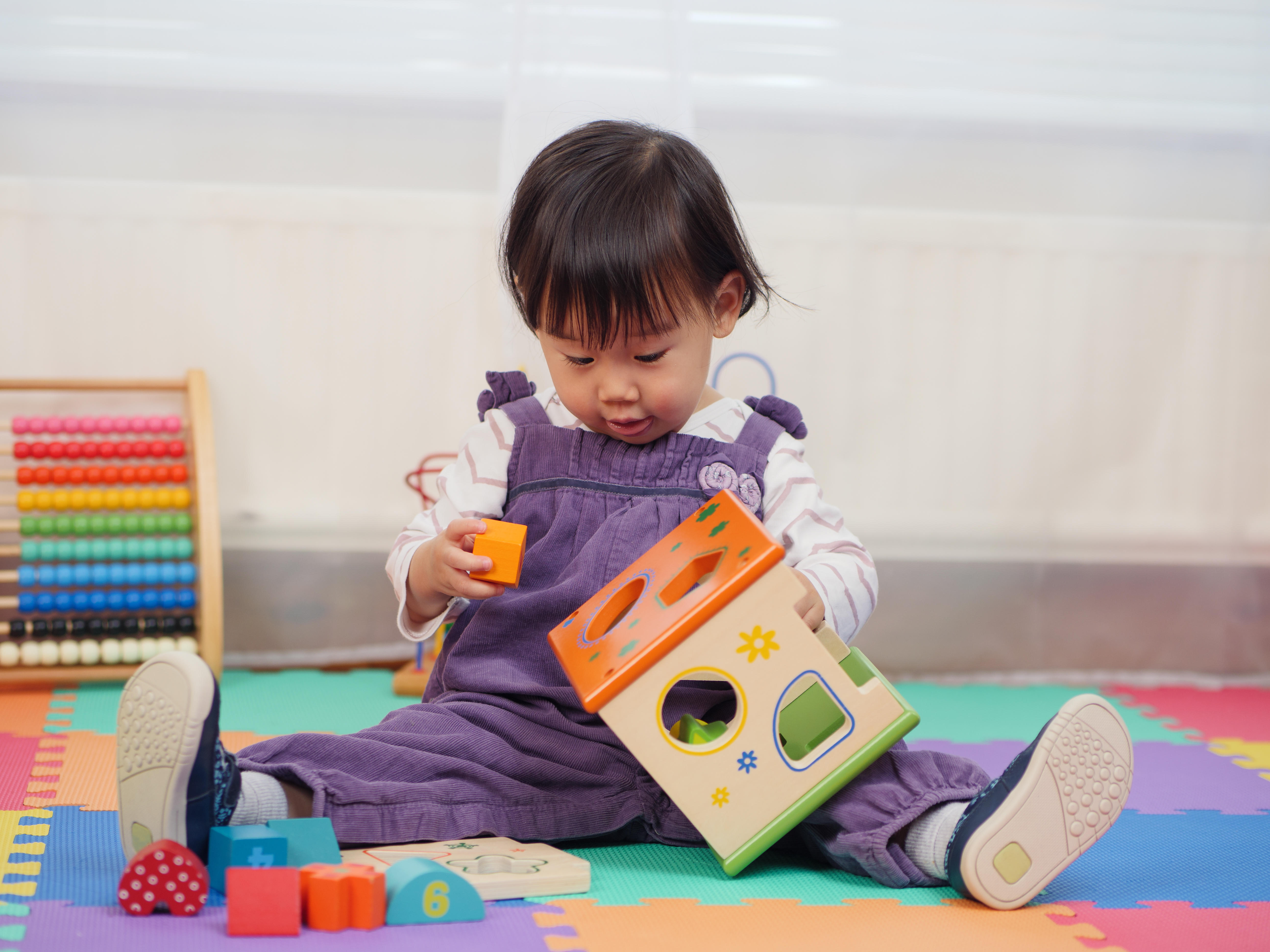 A photo of a young girl playing with a toy.