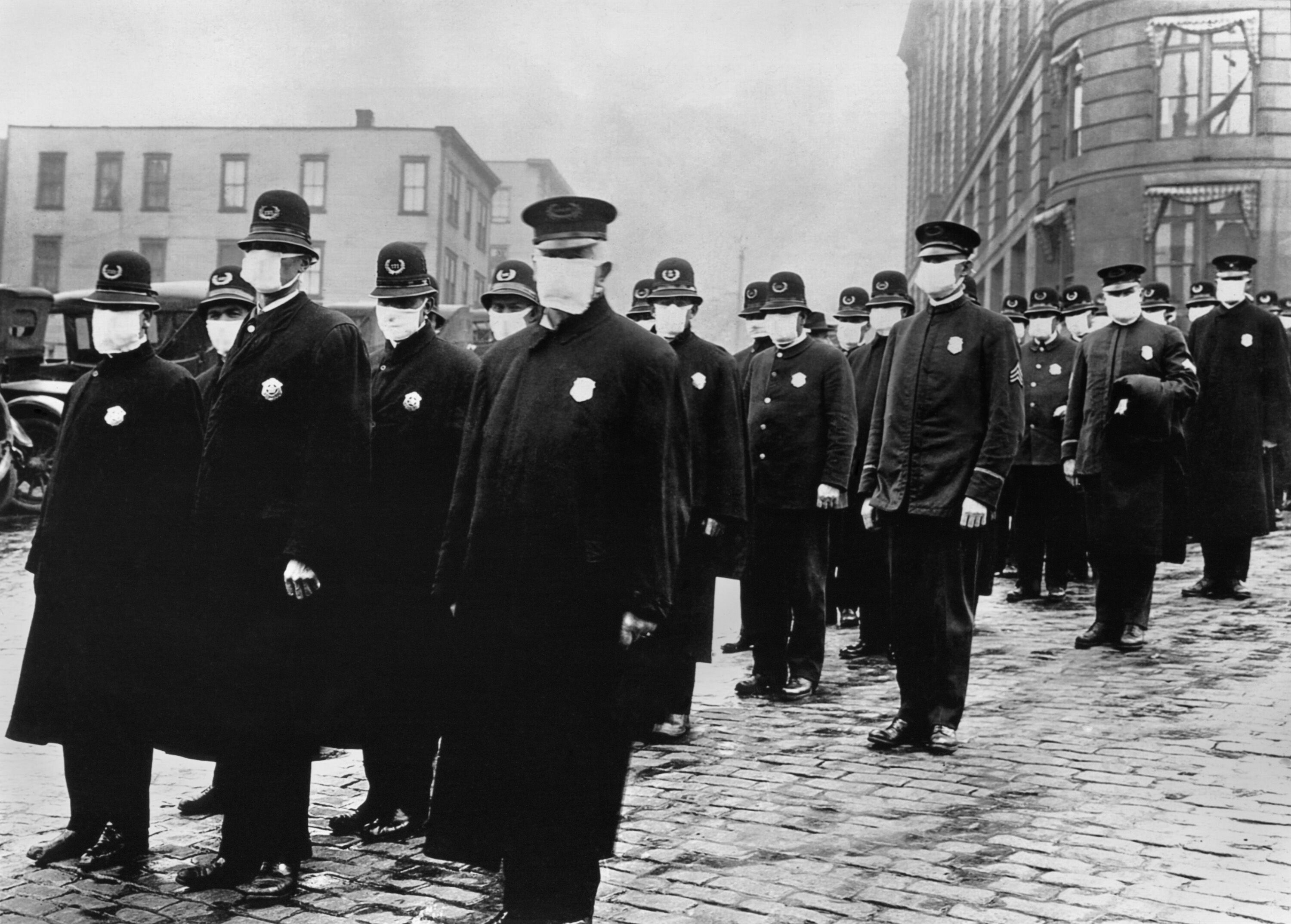A historical photo of policemen wearing gauze face masks during the influenza pandemic of 1918.