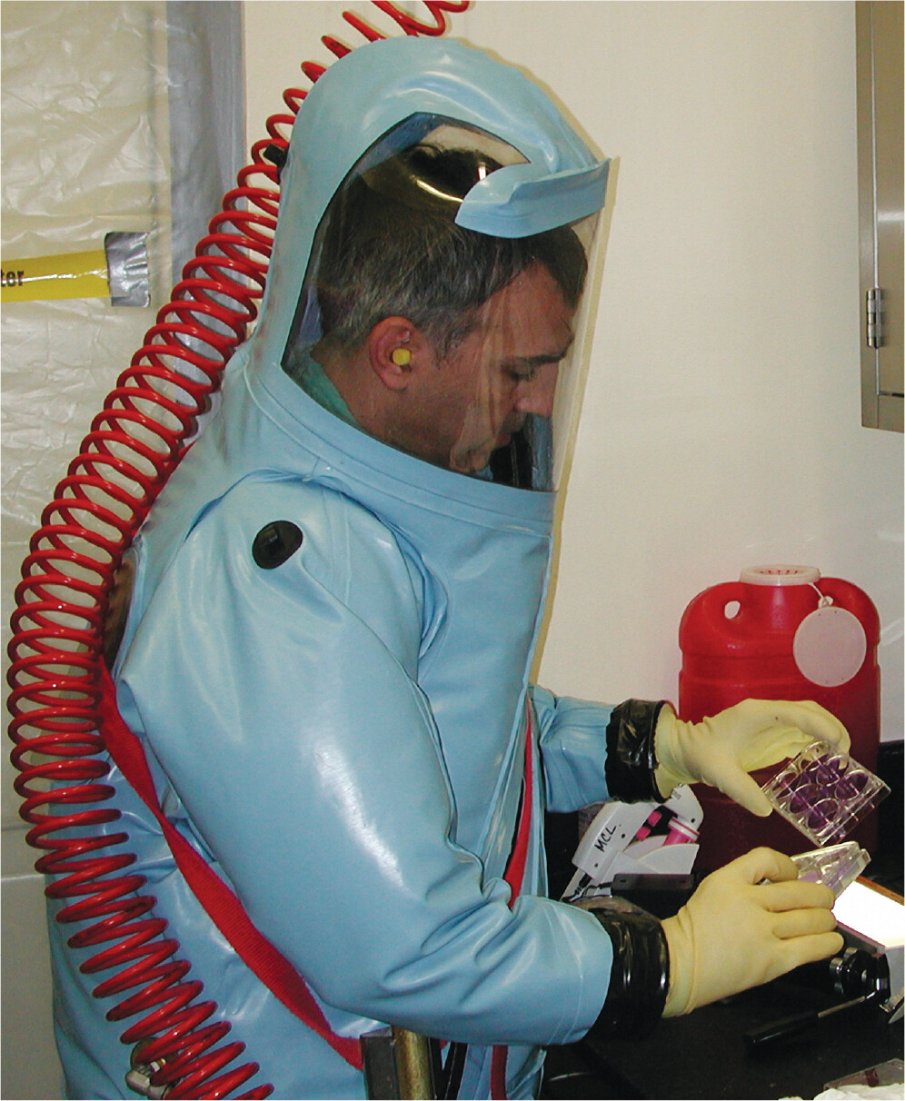 A photo of a doctor working in a positive pressure suit.