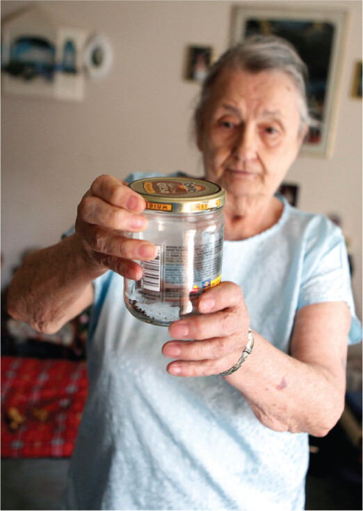 A photo of a person holding a jar containing bed bugs.