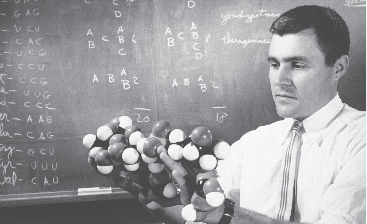 A photo of Carl Woese holding a space filling model.