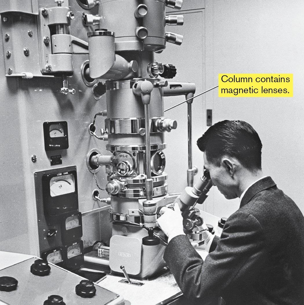 A photo of a scientist looking into the transmission electron microscope in a laboratory.