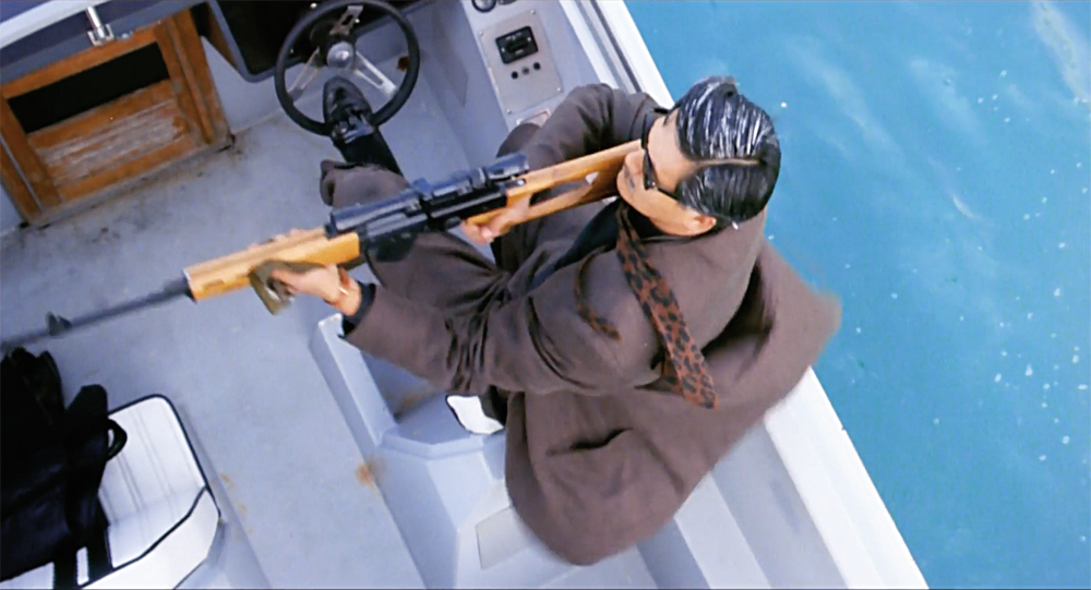 A man on a boat wields a rifle in The Killer.