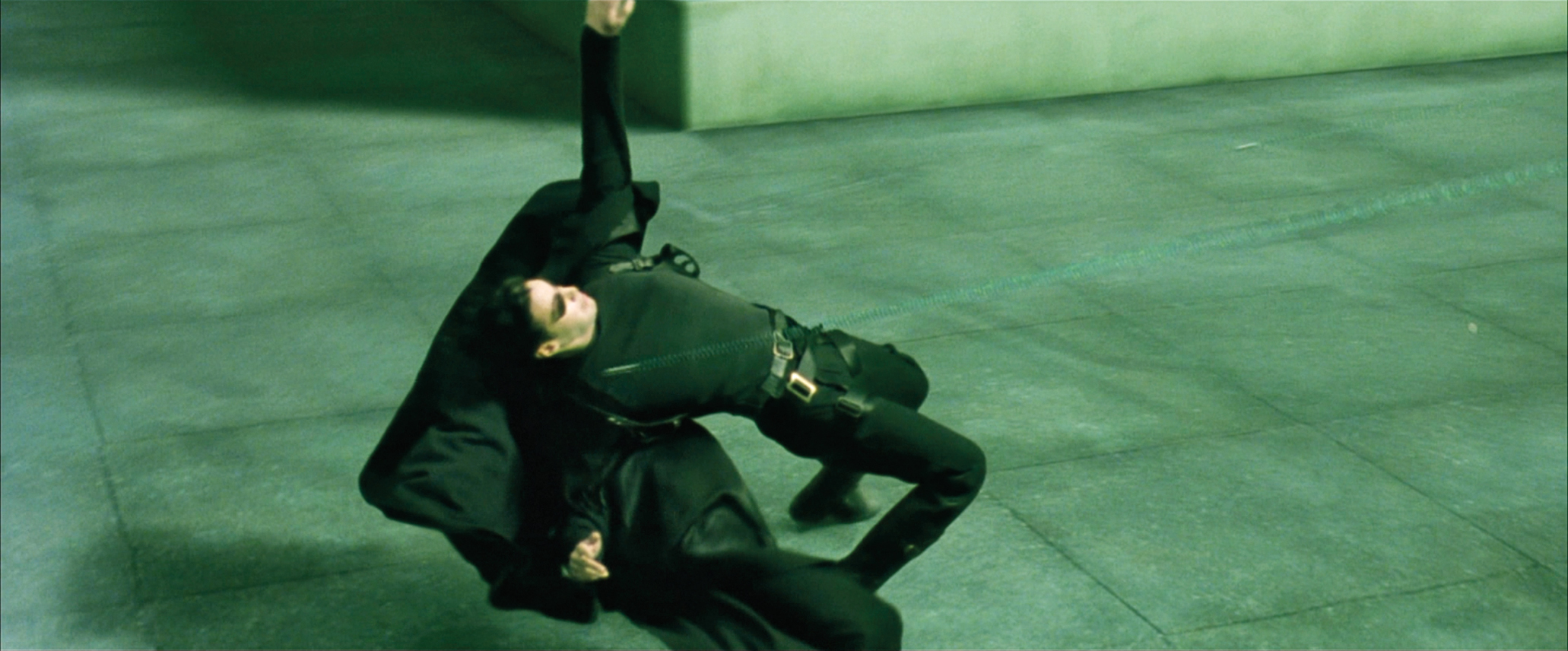 A man in a trench coat bending backwards at the knees dodges a bullet in The Matrix.