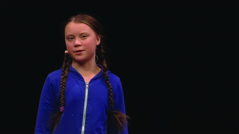 A screenshot of Greta Thunberg speaking on stage.