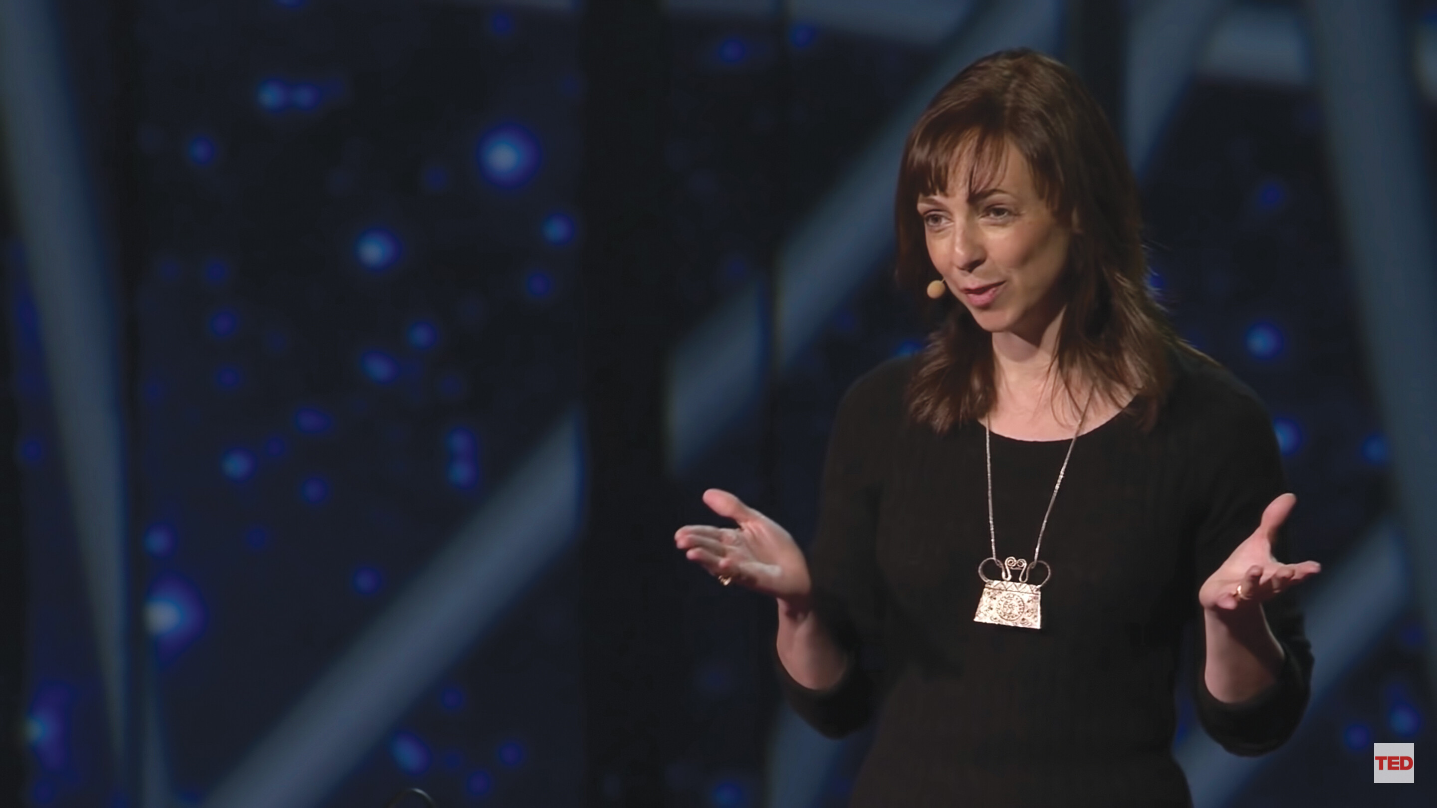 A screenshot of Susan Cain’s TED talk. She stands on a stage in an auditorium.