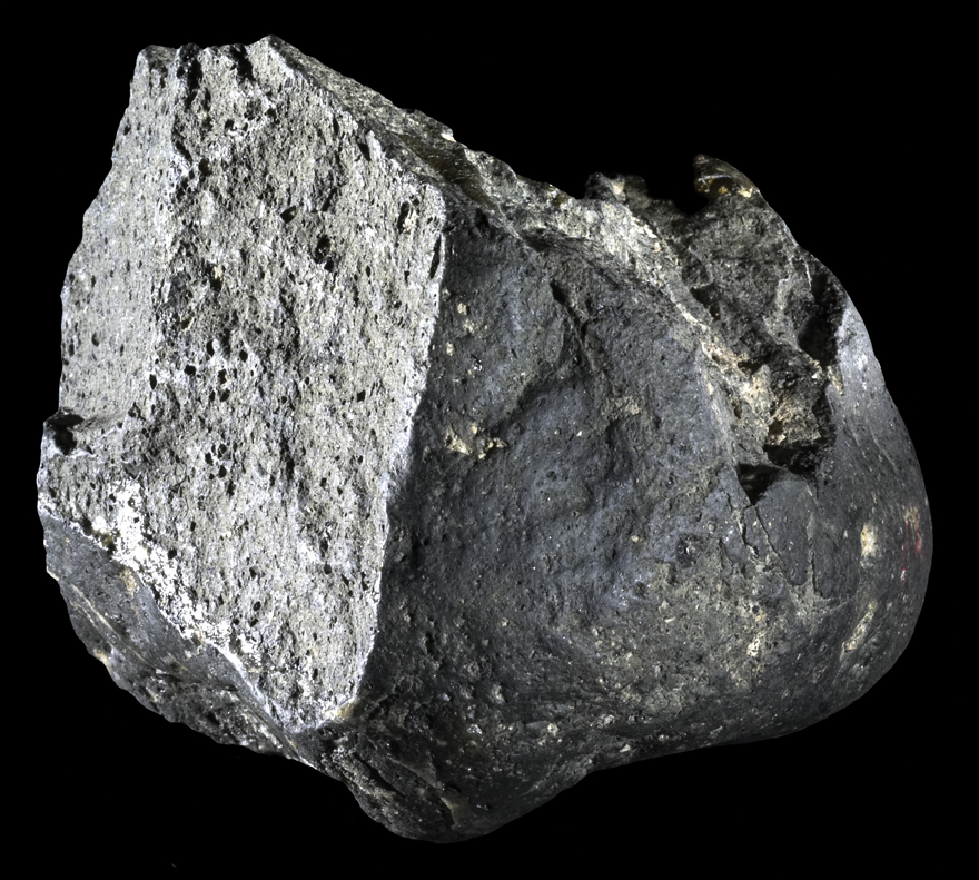 A rock. One side is flat with a crevice that runs through the middle which creates a sharp edge. The other side is slightly rounded.