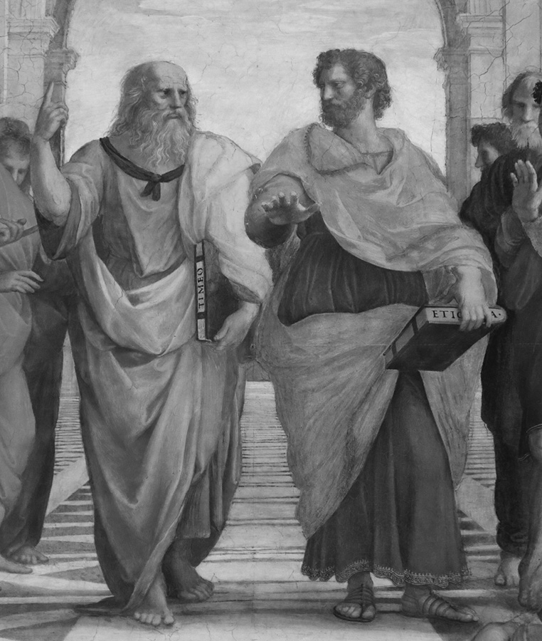 Two men dressed in robes standing next to each other and talking. Both of them are holding books.