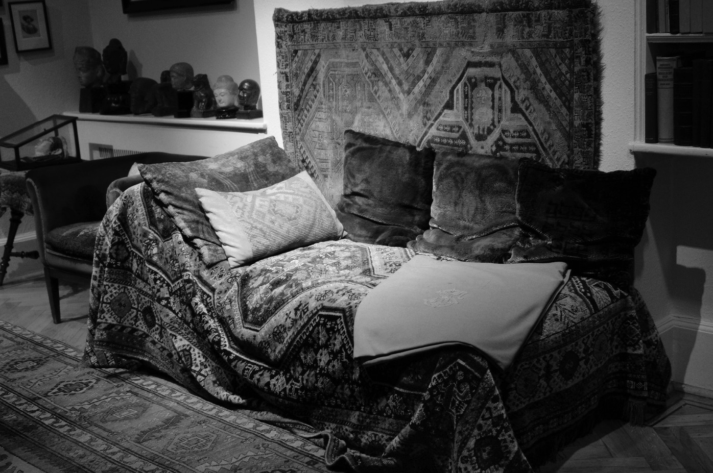 A couch with pillows and blankets on top of it.