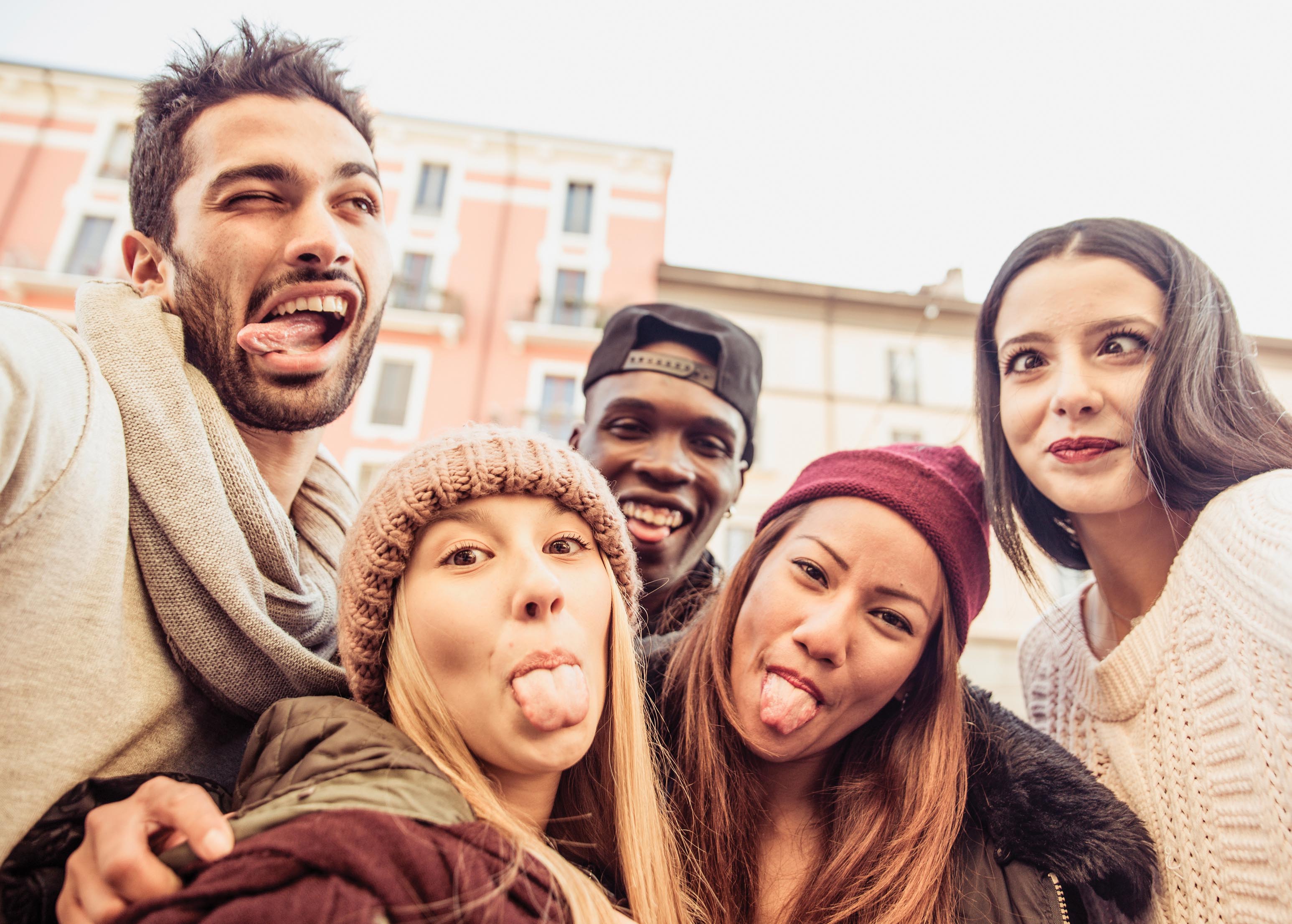 A baby wearing glasses and looking at an open book on its lap.