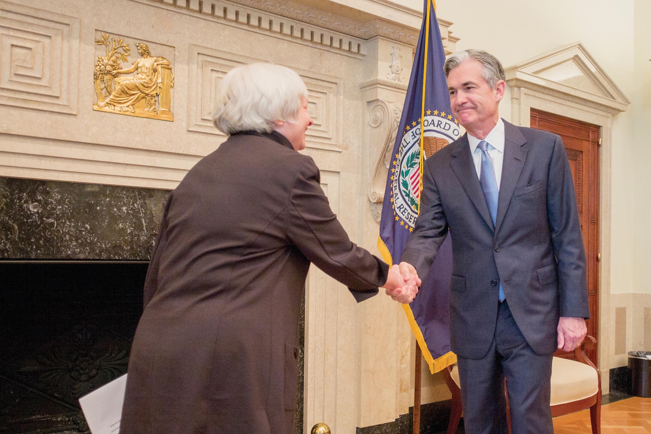 Jerome Powell shaking hands with Janet Yellen.