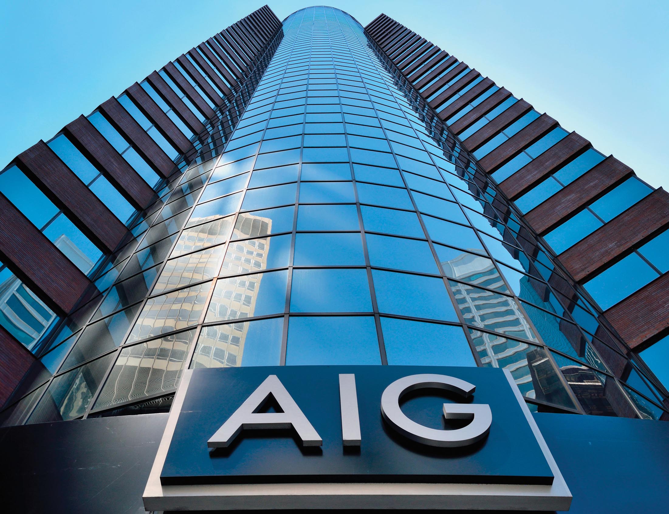 A tall, glass fronted building with an AIG sign.