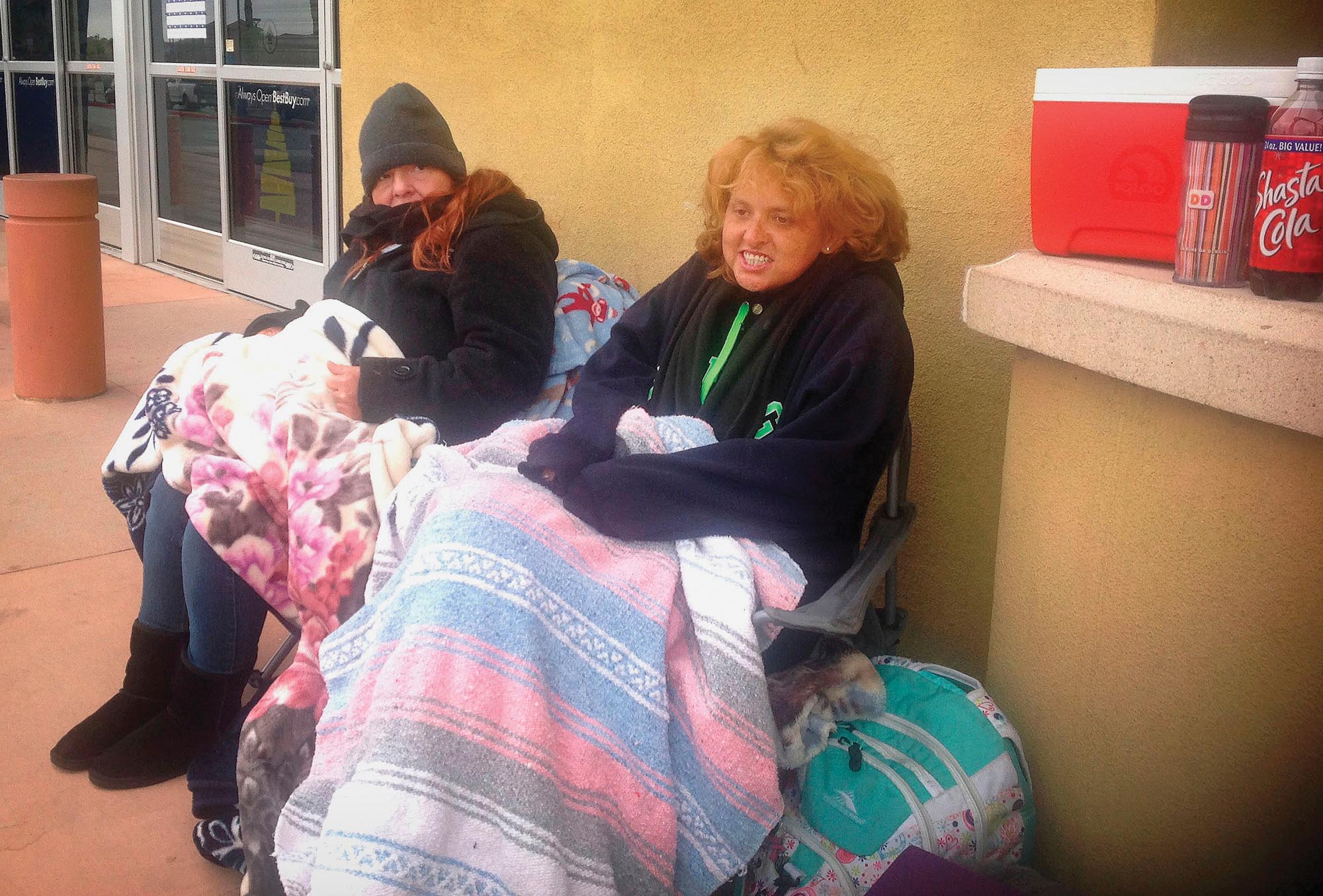 Two people who have been waiting a long time outside a store.
