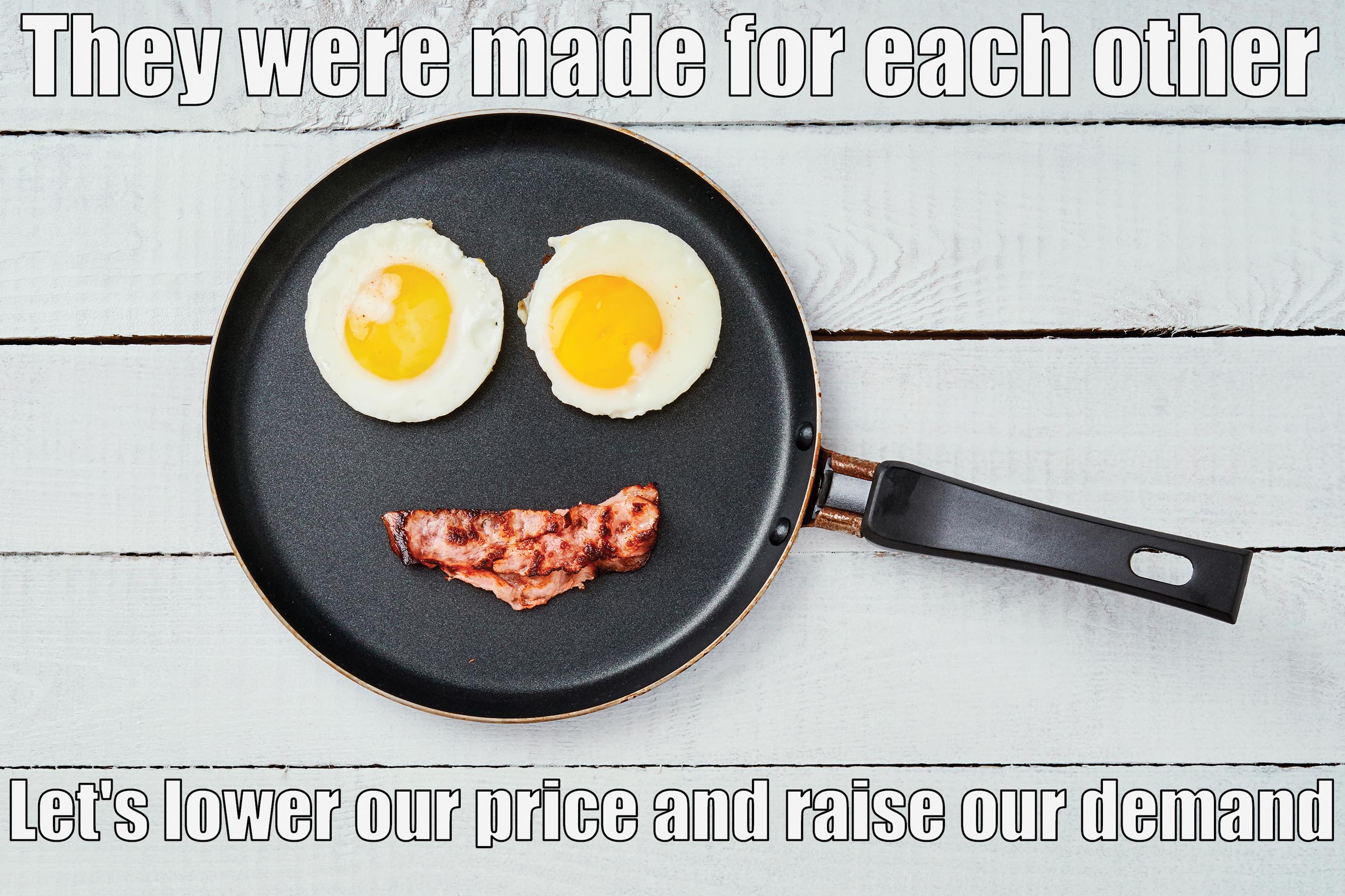 Two eggs served sunny side up and a strip of bacon in a frying pan.