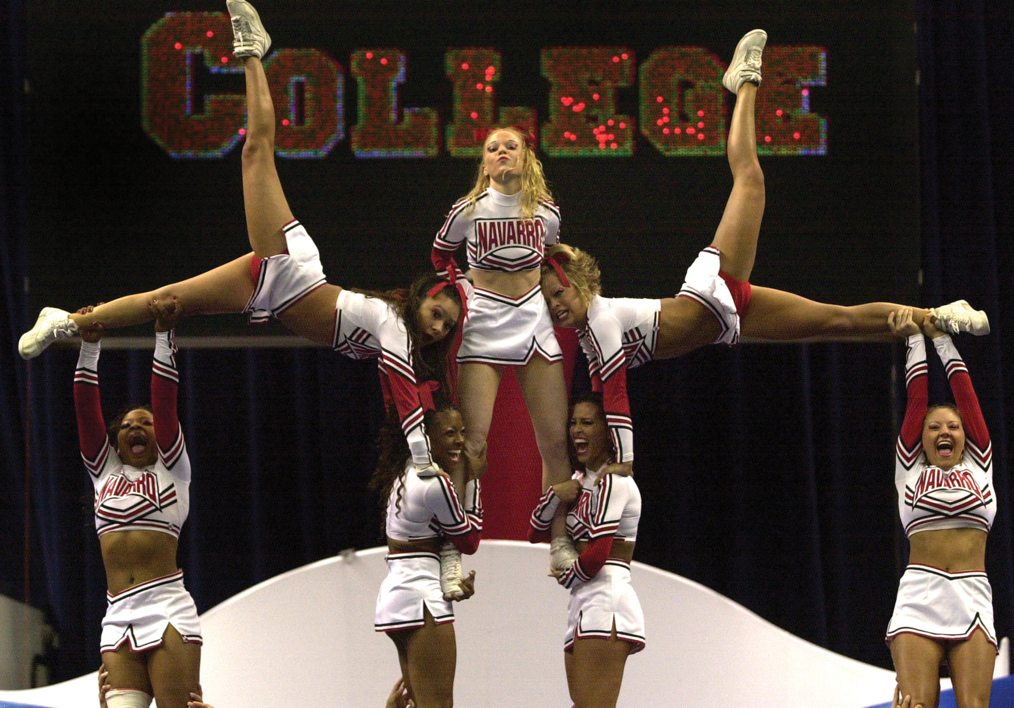 A group of seven young cheerleaders performing a stunt.