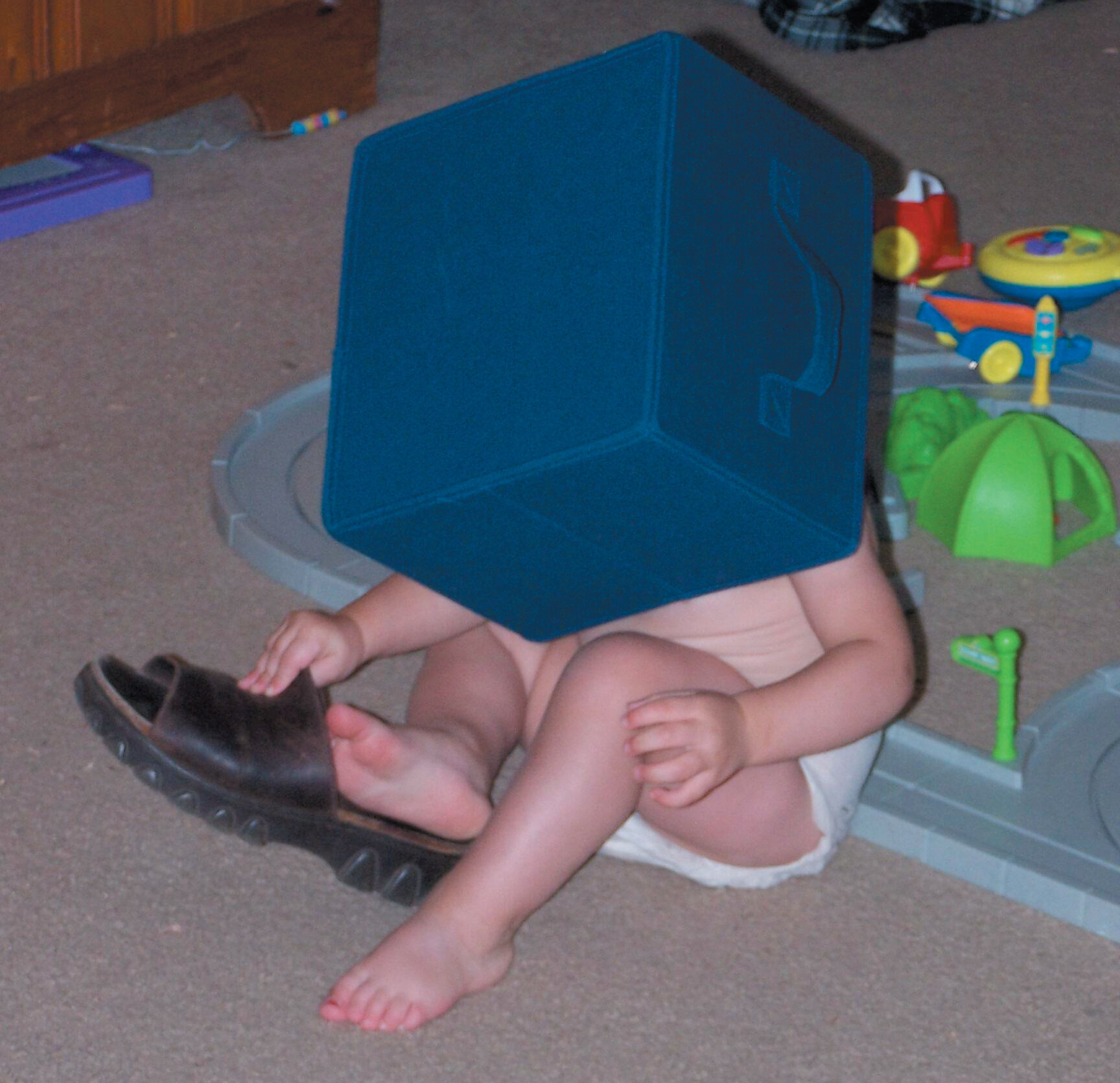 A photo of an infant with the head inside of a blue box.