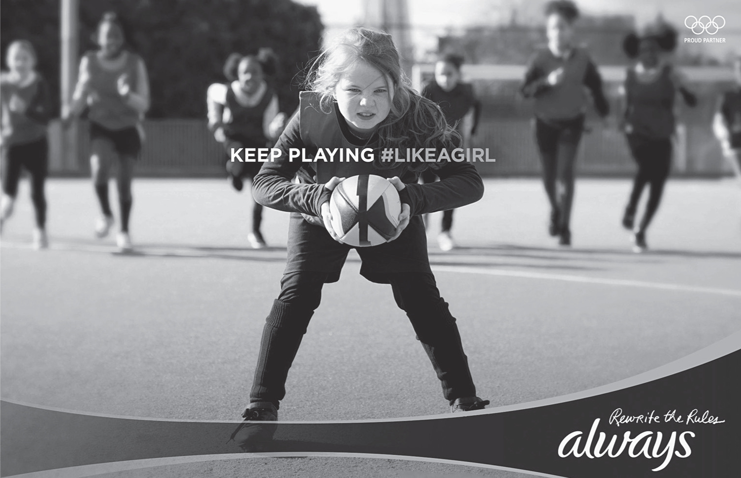 A print ad features a photo of a young girl clutching a rugby ball and the caption “Keep Playing hashtag Like a Girl.”