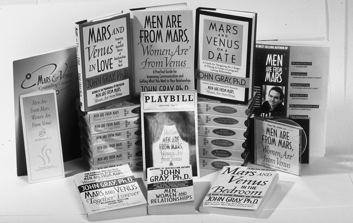 A photo shows a stack of books written by John Gray.