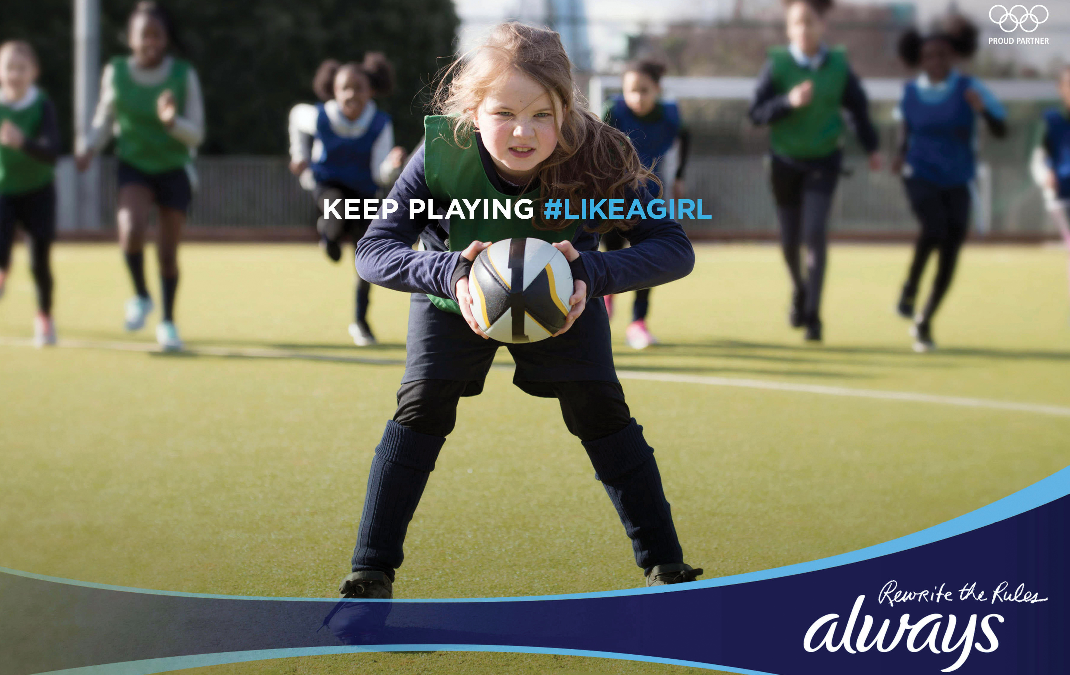 A print ad features a photo of a young girl clutching a rugby ball and the caption “Keep Playing hashtag Like a Girl.”