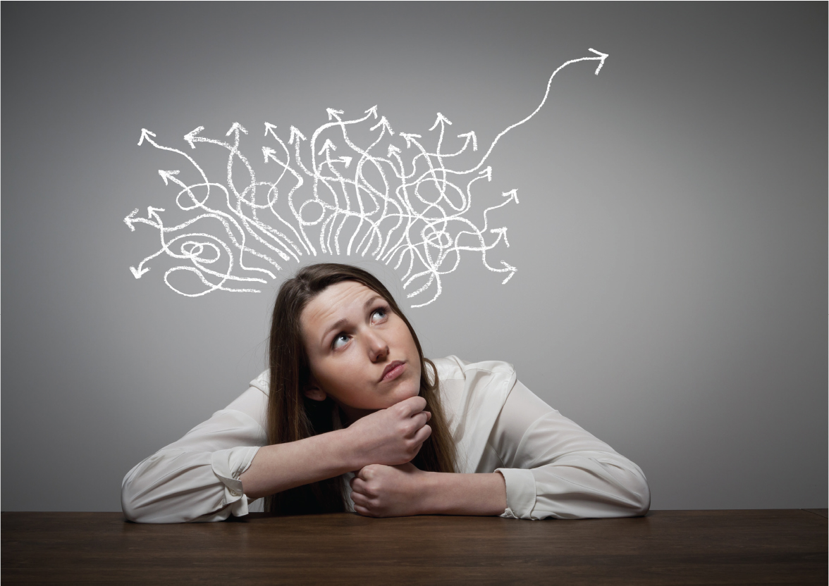 A photo shows a woman sitting at a table reflecting.
