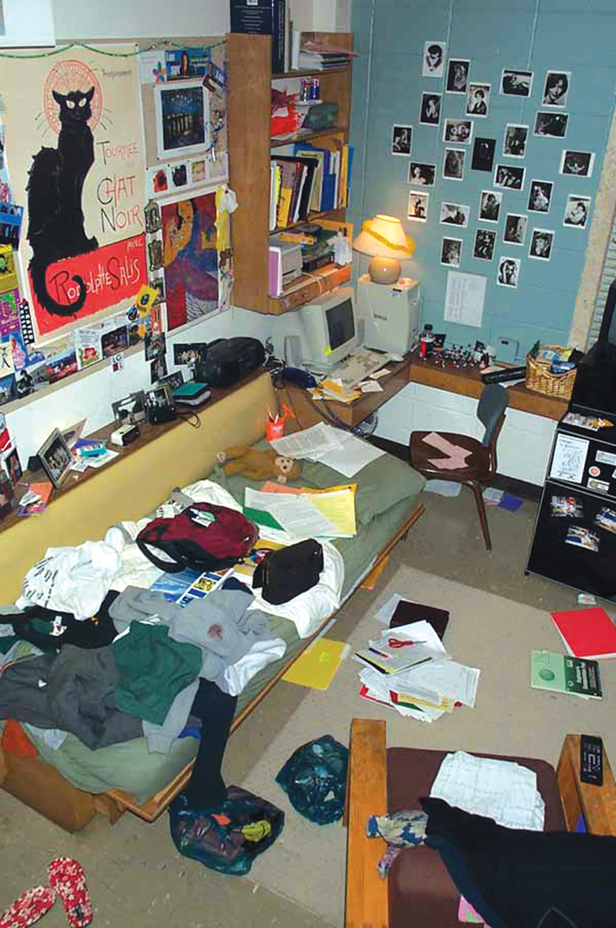 A photo shows a dorm room that is very messy and disorganized.