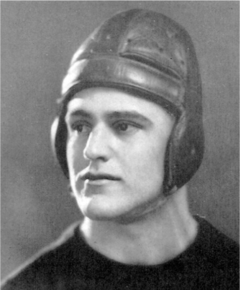A black-and-white portrait of a white man wearing a leather helmet.