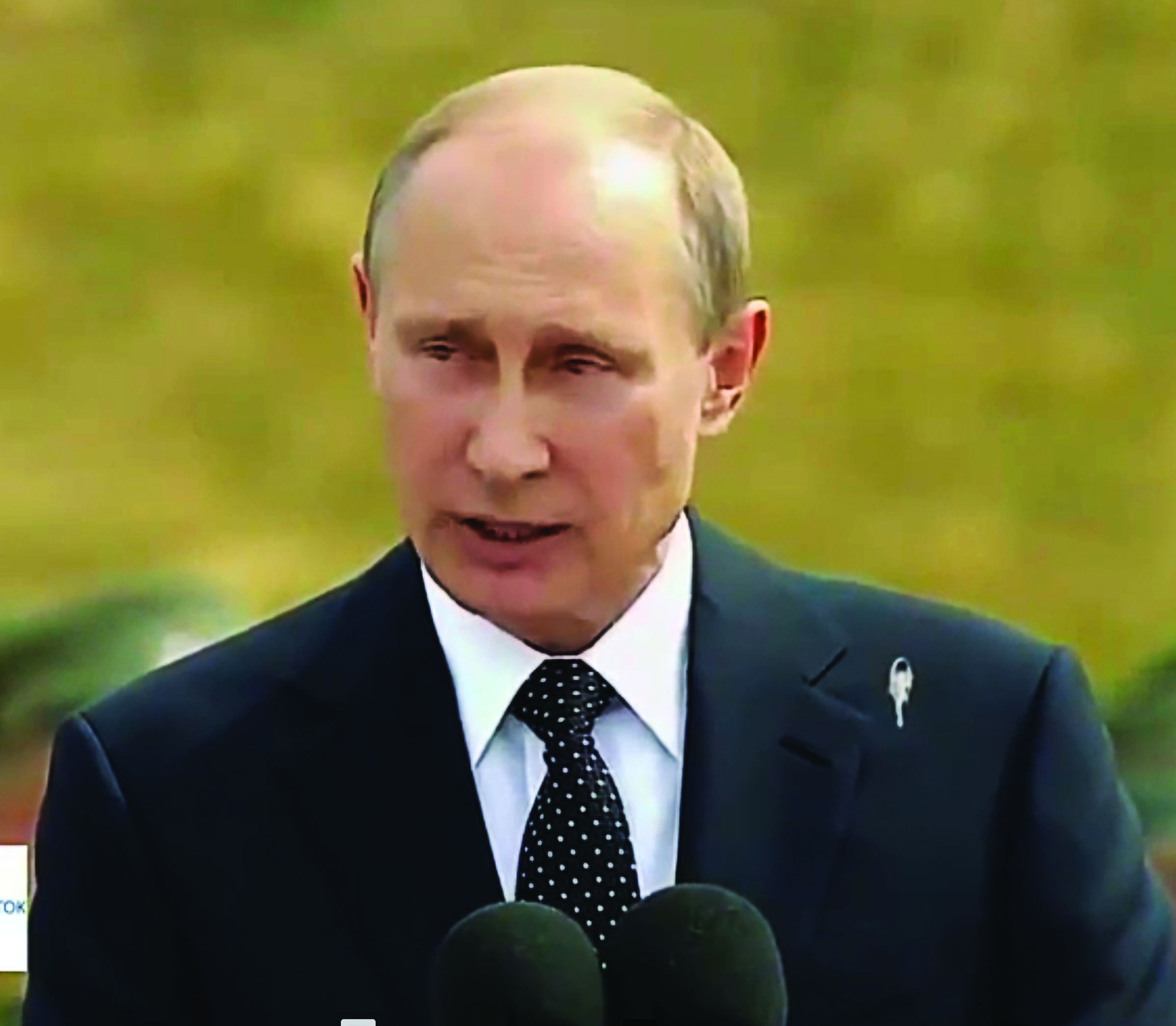 Vladimir Putin wearing a suit with a black polka-dotted tie.