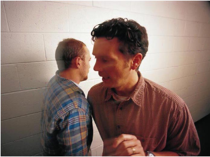 Two male students showing flashes of anger as they pass each other in a hallway.