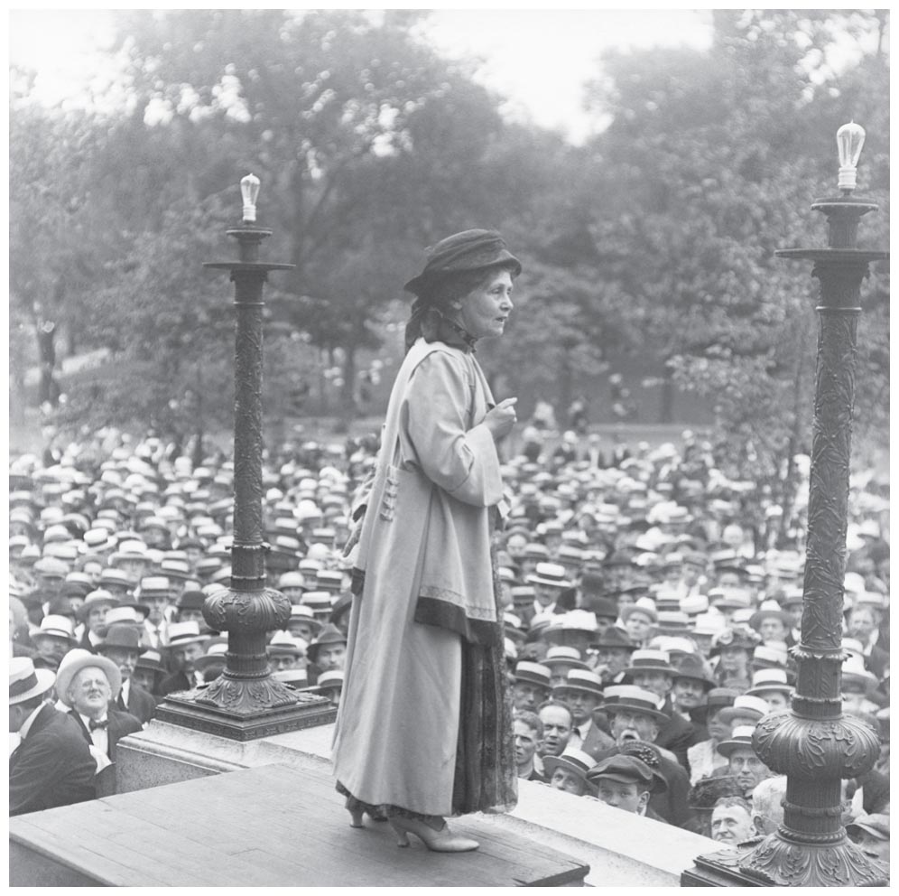 A British suffragette, Emmeline Pankhurst, stands on a platform and addresses a huge crowd.