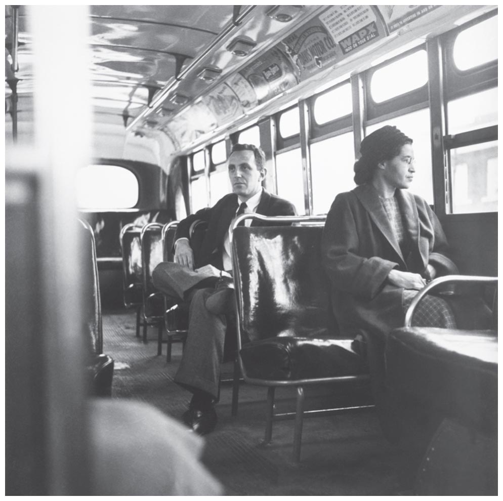 A black-and-white photo shows Rosa Parks sitting on the front seat of a bus and a man sitting on the seat just behind her.