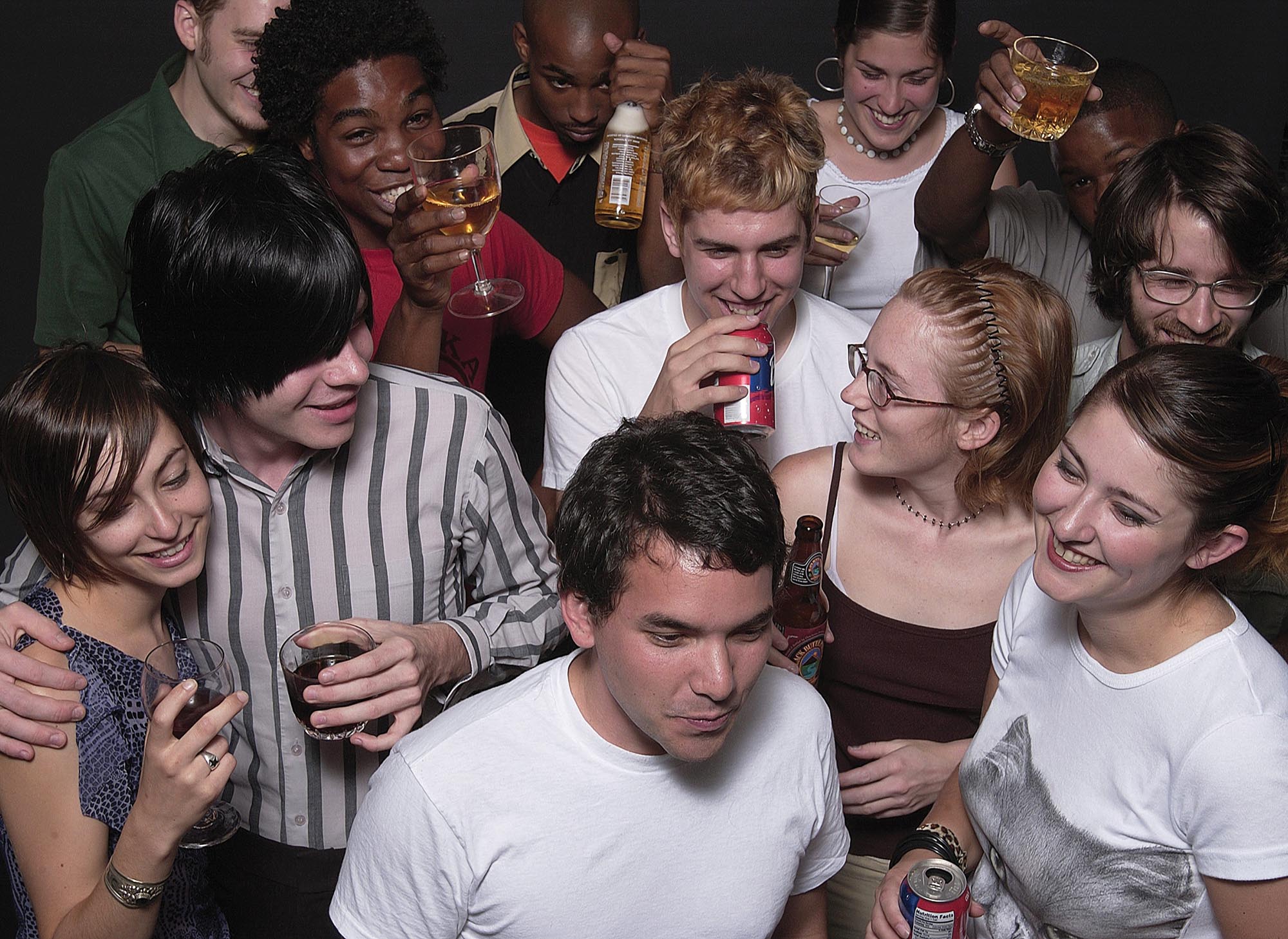 A group of young people holding and consuming alcohol.