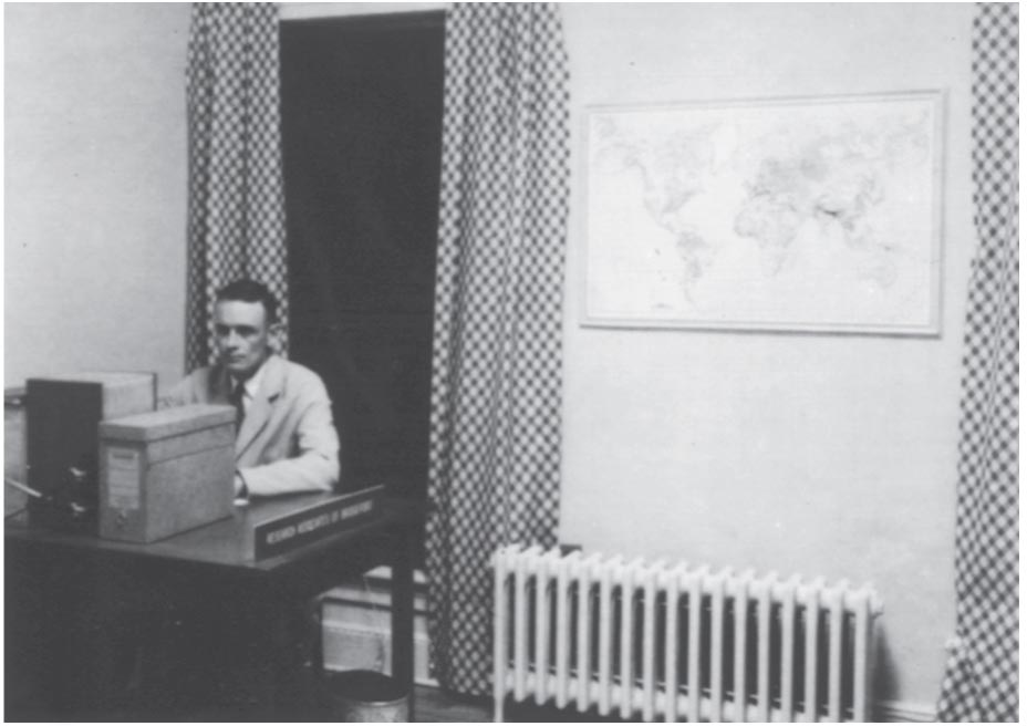 A black-and-white photo of a person sitting in an office.