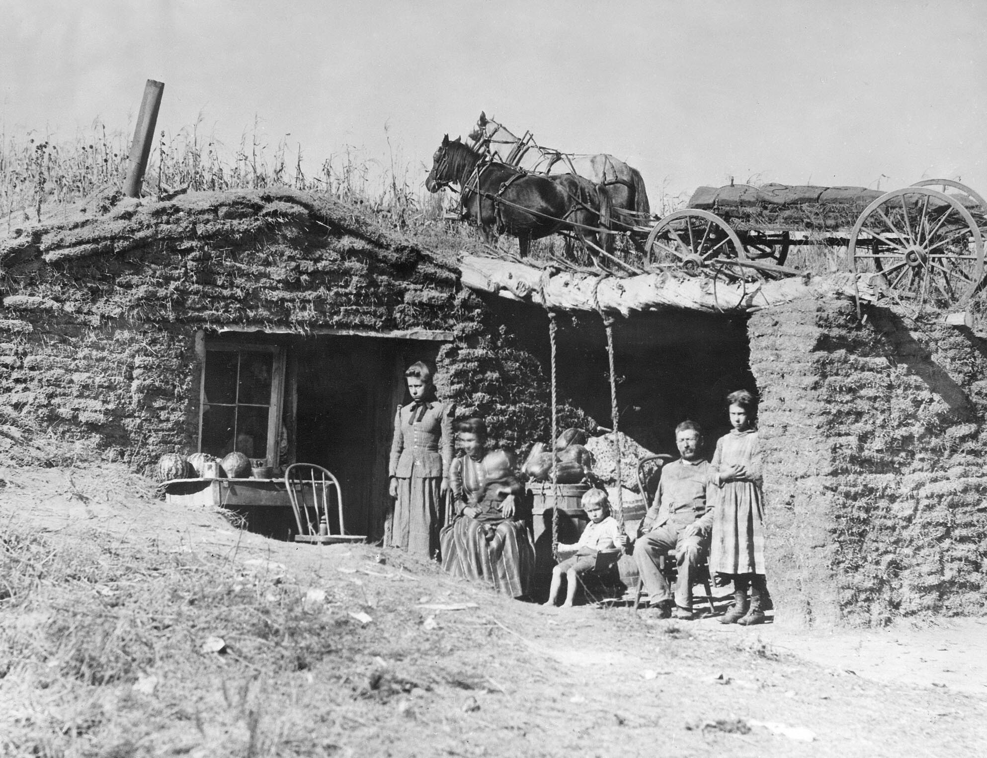 A family of six in front of their sod dwelling.