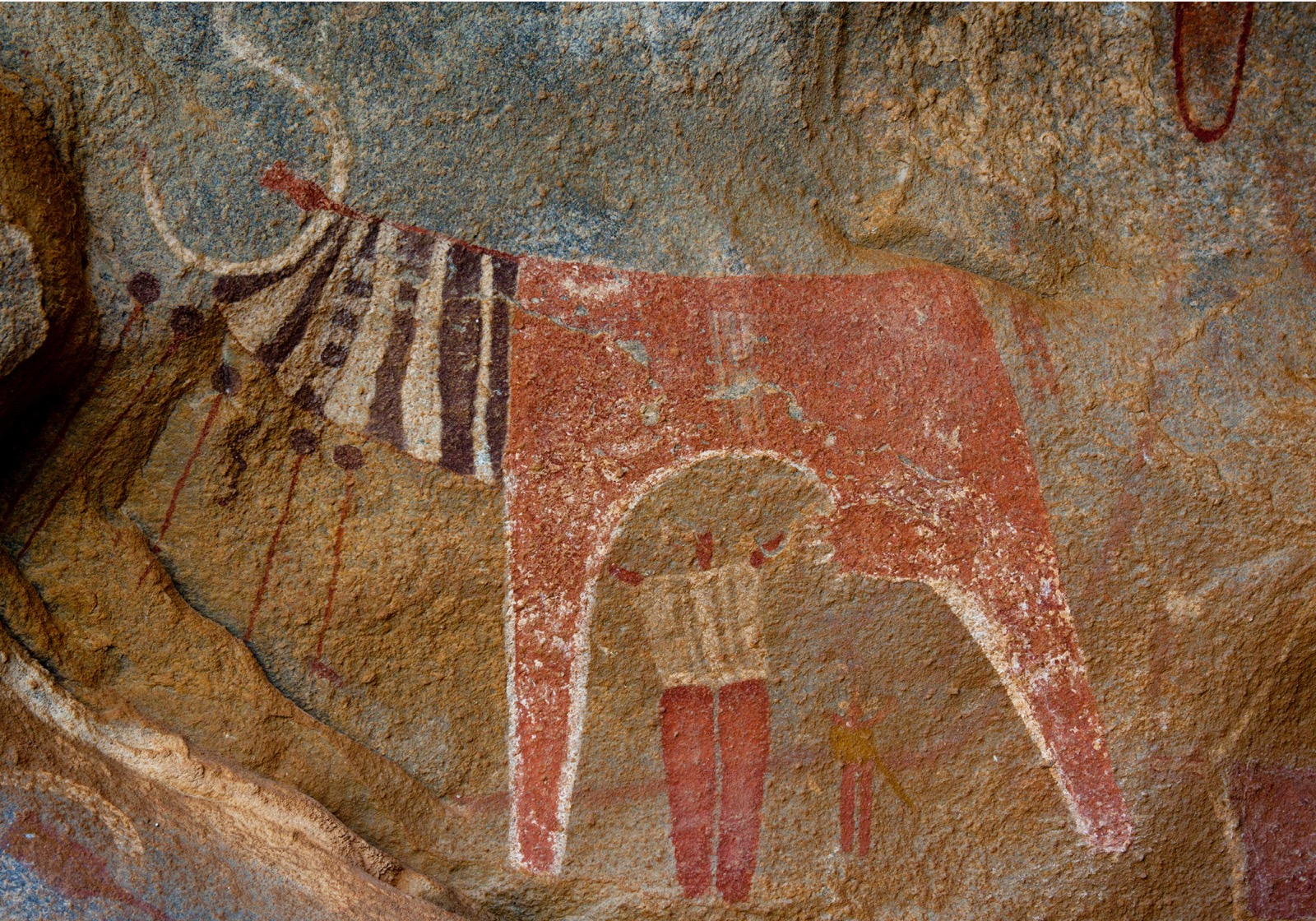 Rock art painting of a person milking a cow.