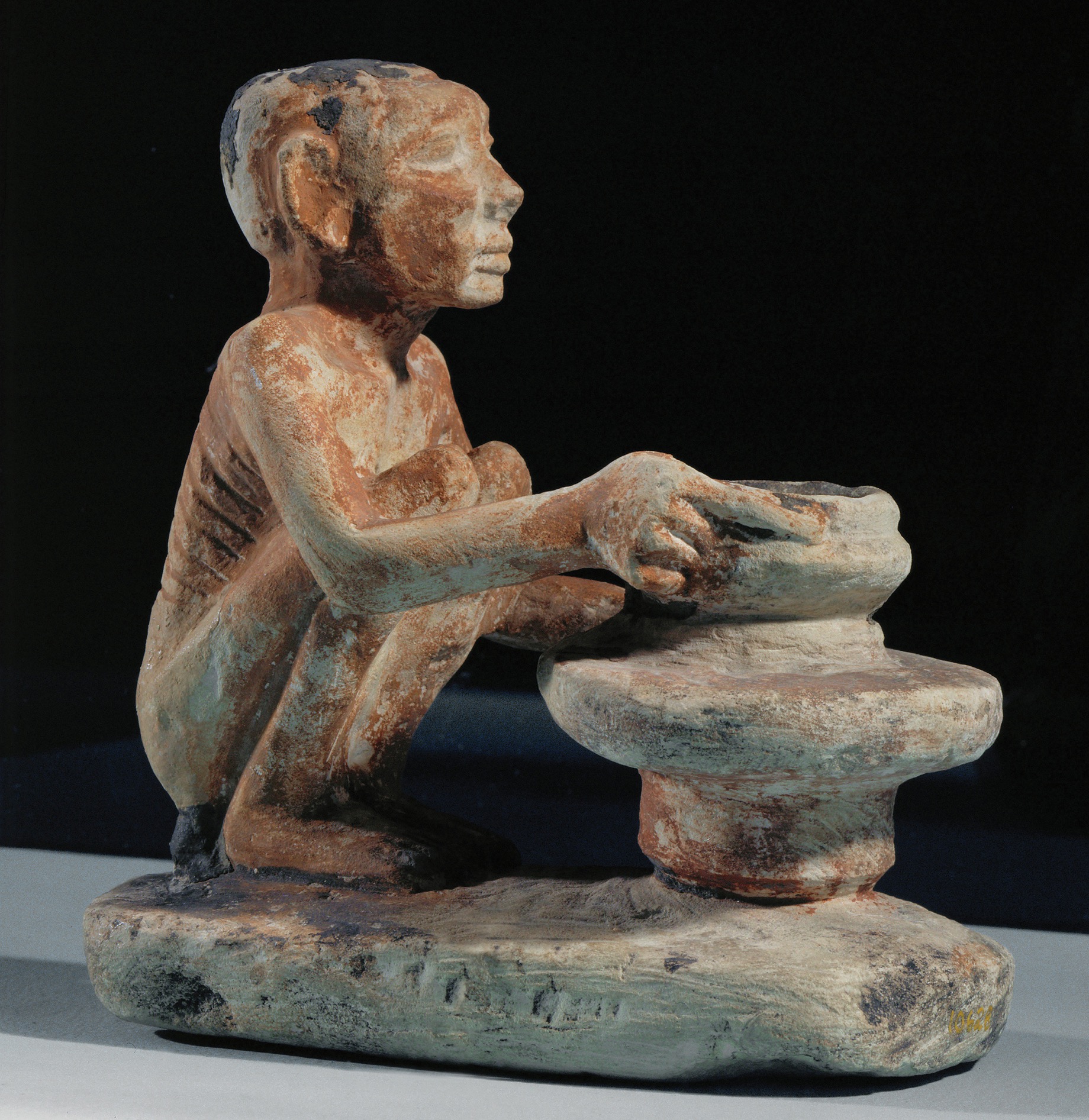 An Egyptian statuette shows a potter squatting and working at a potter’s wheel.